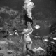 Rita King as a young mermaid feeding fish. Photo Courtesy of Rita King